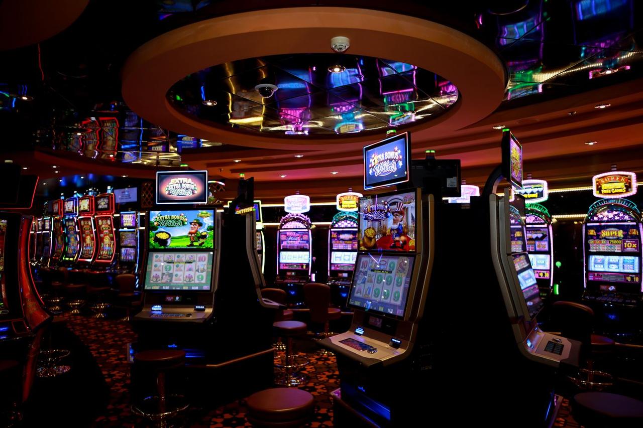 Barisan mesin slot berwarna di lantai kasino