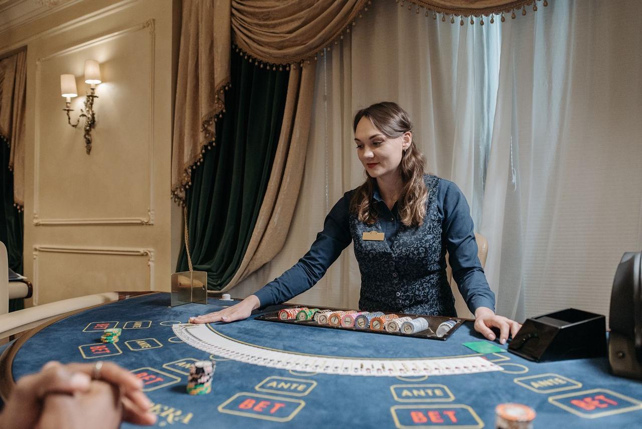 Dealer casino menyusun kartu dan chip di meja permainan