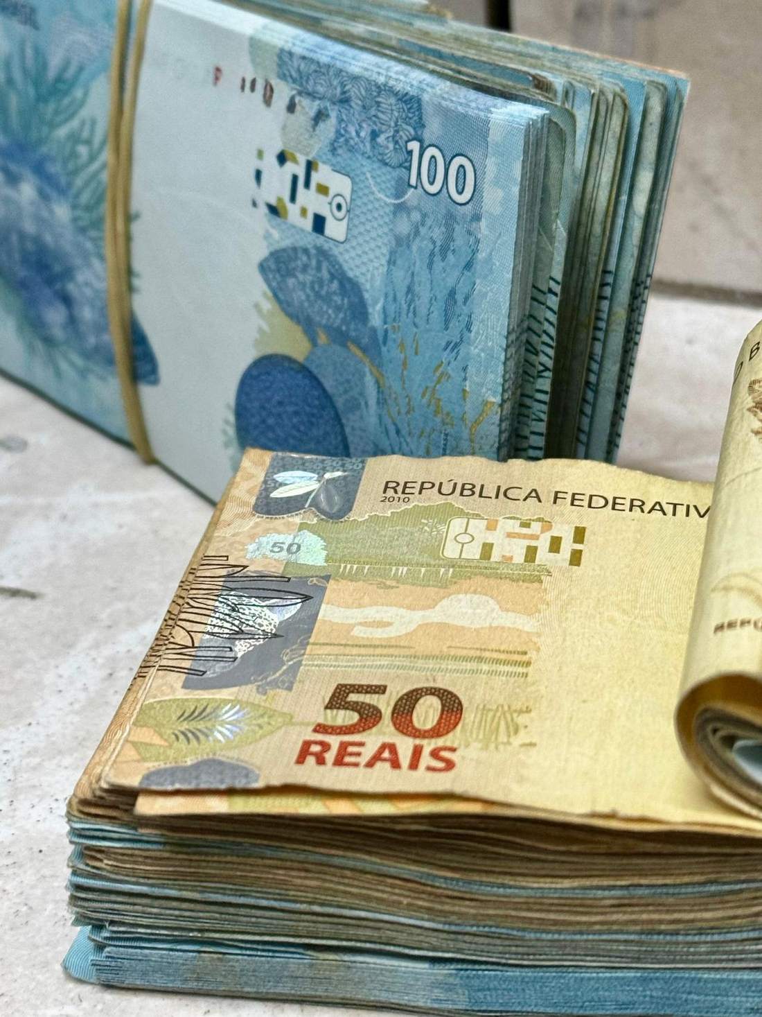 Sejumlah uang kertas rupiah tersusun di atas meja
